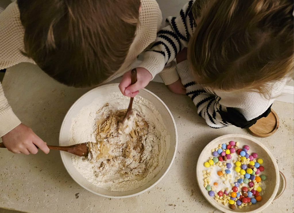 Kids mixing cookie dough for the Little Lady Baker Rainbow Cookie Mix, with colourful chocolate sweets ready to add