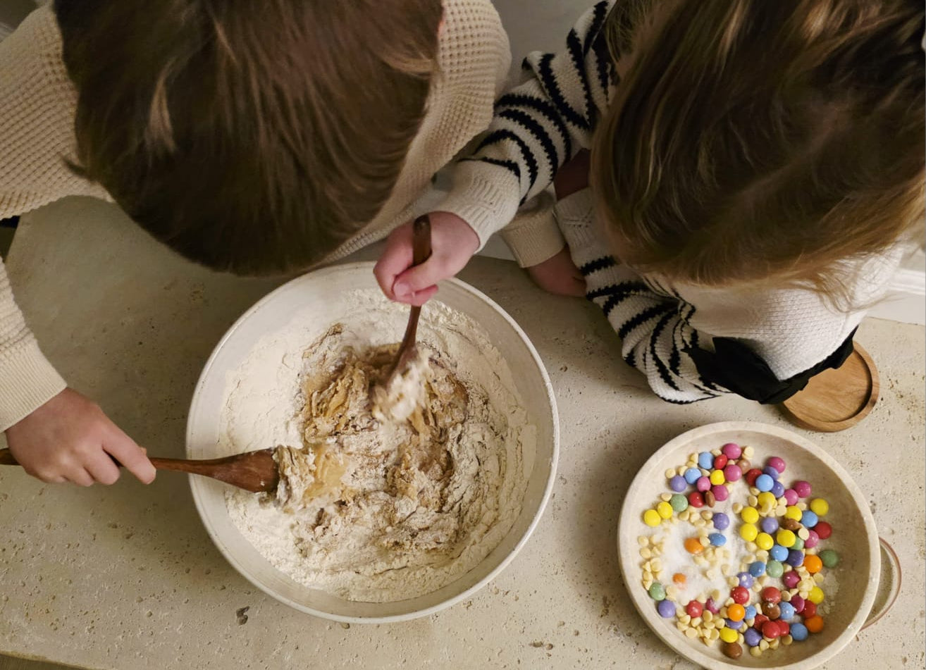 Kids mixing cookie dough for the Little Lady Baker Rainbow Cookie Mix, with colourful chocolate sweets ready to add