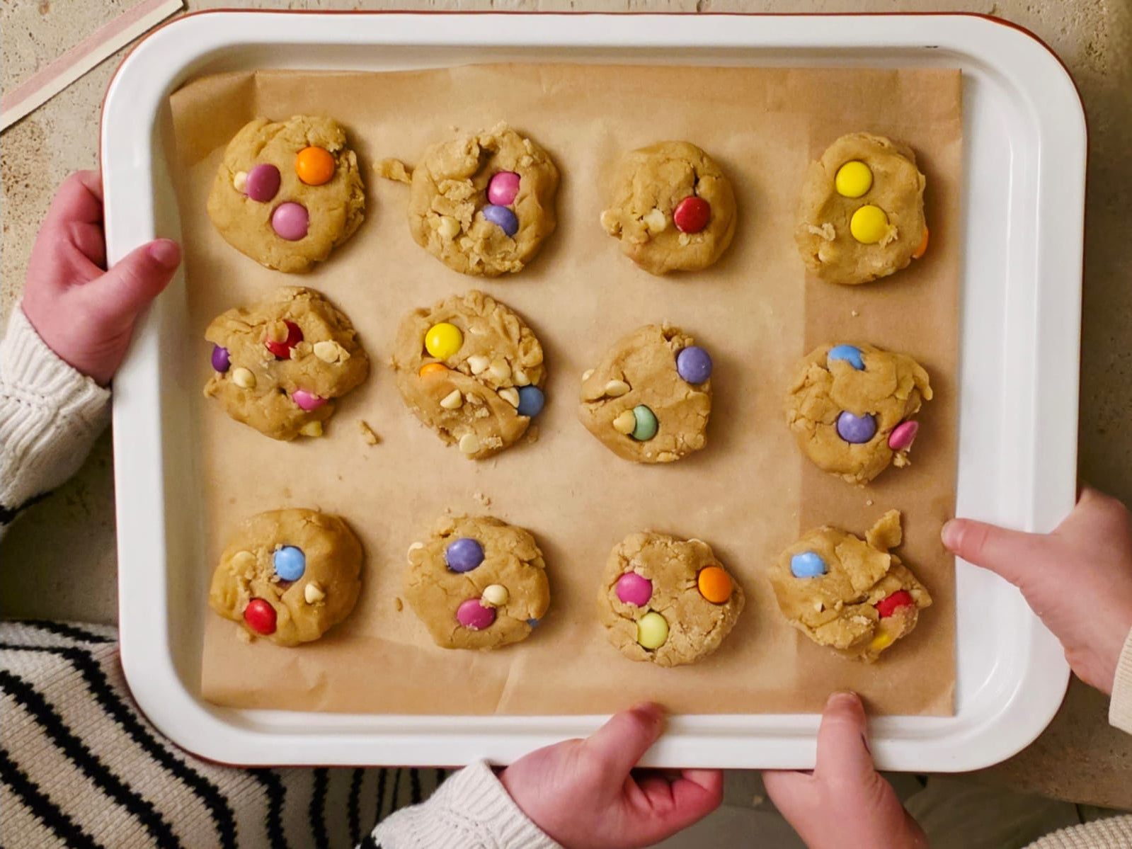 Kids holding a tray for unbaked rainbow cookies made from the Little Lady Baker Rainbow Cookie Mix
