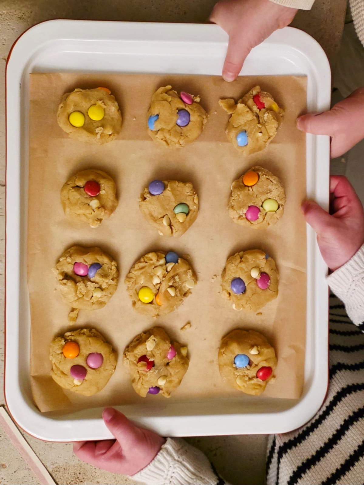 Chidren holding a tray of rainbow cookie dough balls made from Little Lady Baker Rainbow Cookies Mix