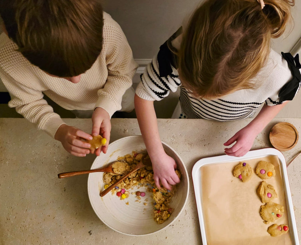 Kids baking rainbow cookies using Little Lady Baker Rainbow Cookie Mix, shaping dough and placing it on a tray