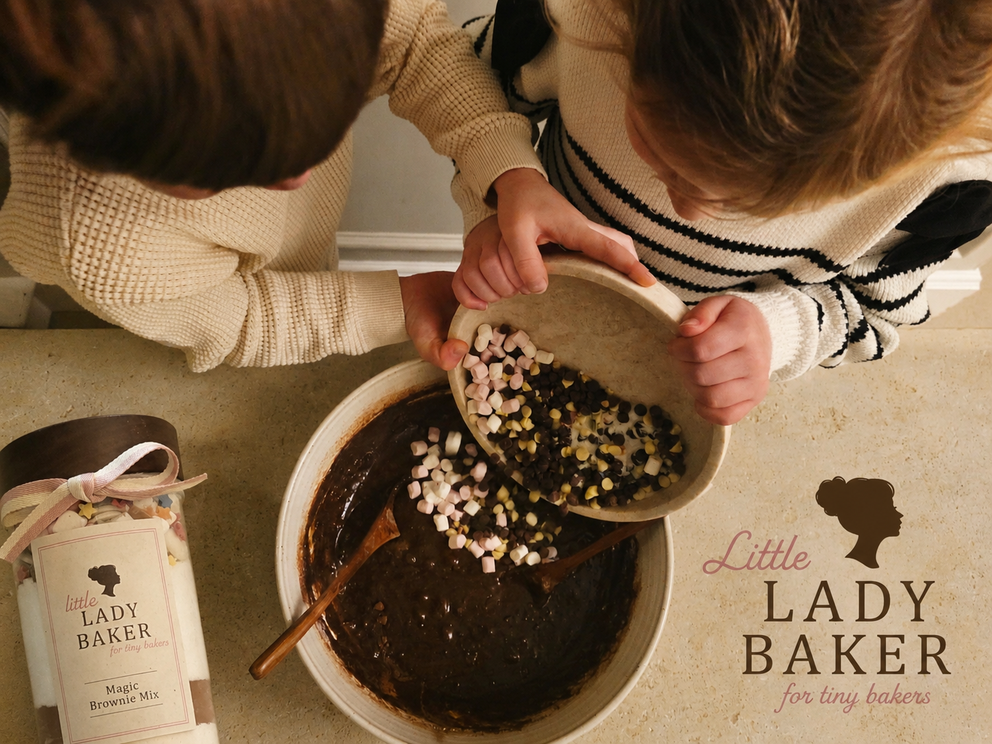 Two children mixing ingredients in a bowl with a Little Lady Baker product on a countertop.